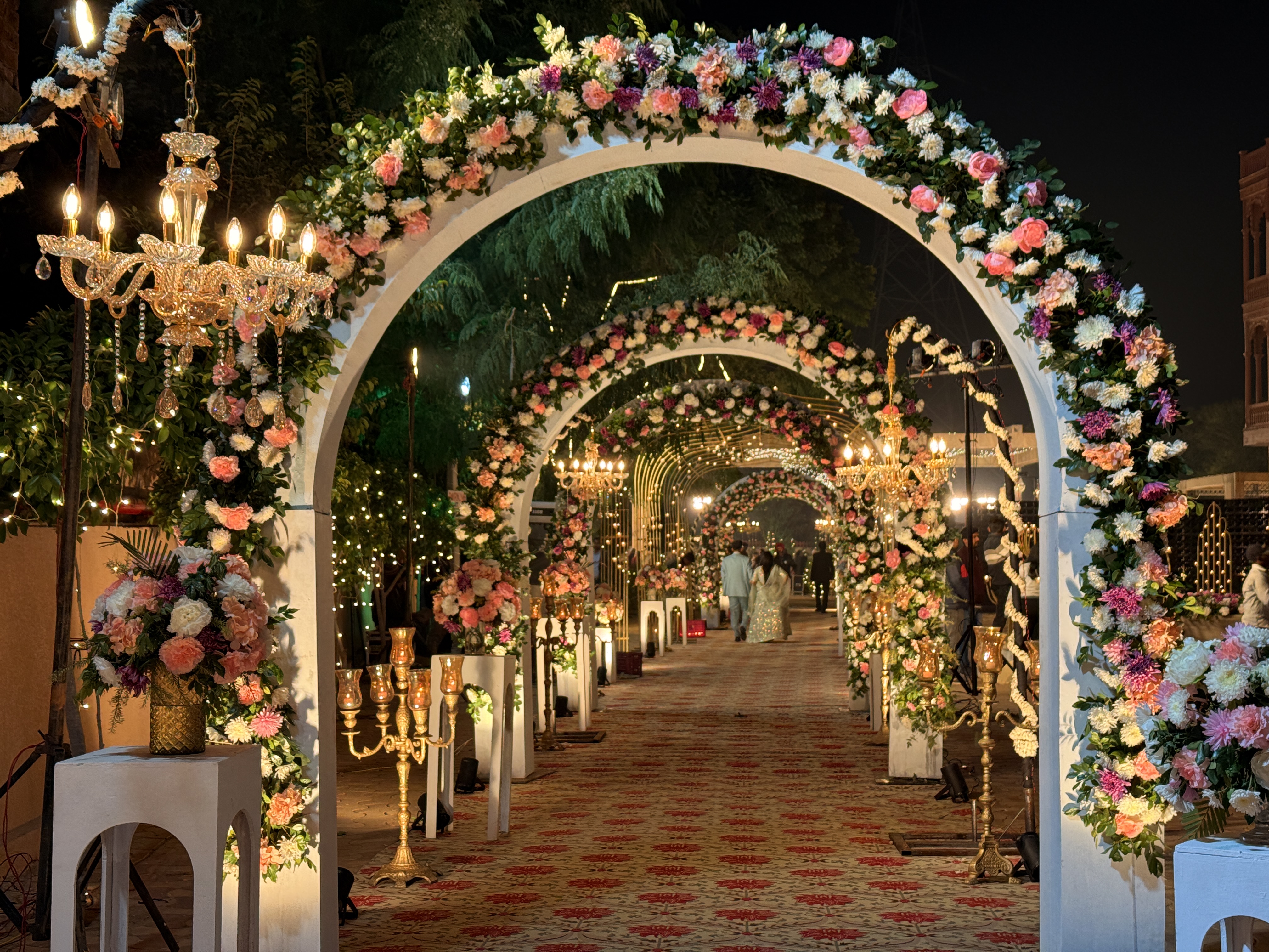 Close-Up-Floral-Wedding-Entry-Arch-With-Chandeliers-And-Lights-Wedifys-Destination-Wedding-Planner-03272026