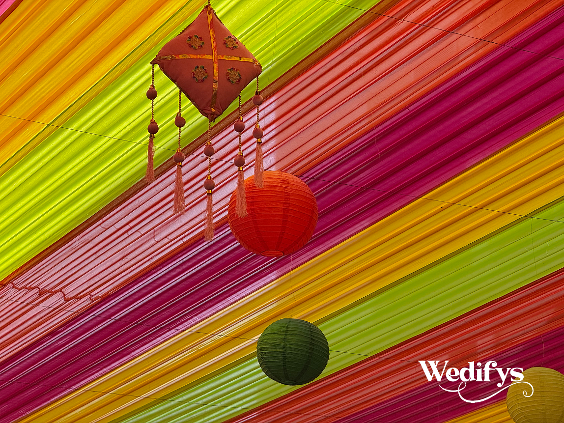 Haldi-Ceiling-Decor-with-Vibrant-Drapes-and-Hanging-Lantern-Installation-04242026