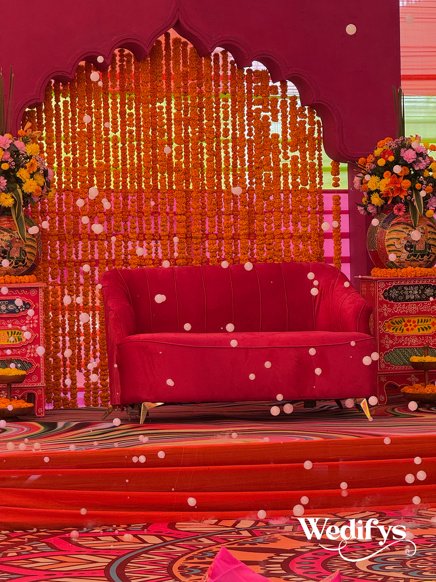 Haldi-Couple-Stage-with-Backdrop-and-Red-Sofa-Seating-04242026