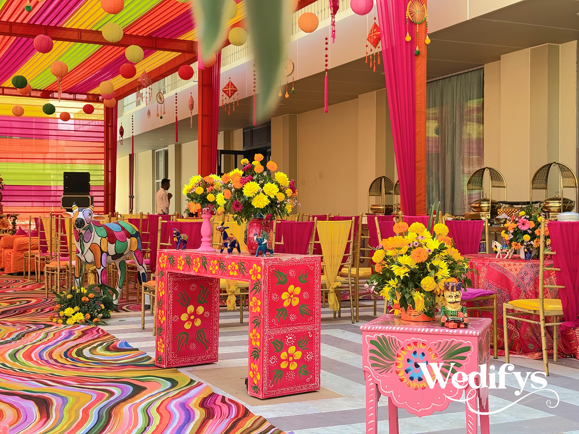 Haldi-Dining-Setup-with-Colorful-Tables-and-Floral-Centerpiece-Arrangement-04242026