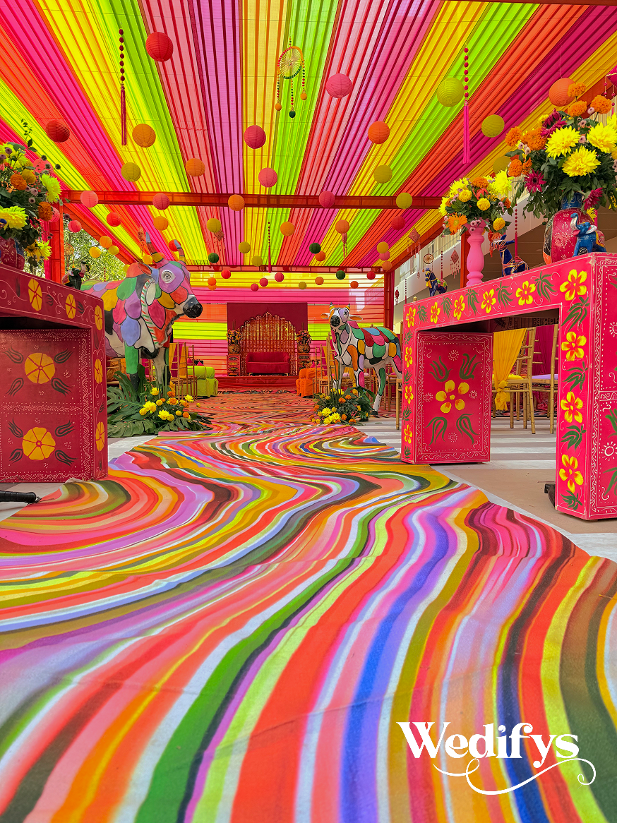 Low-Angle-Haldi-Walkway-Shot-with-Dramatic-Colorful-Carpet-and-Canopy-04242026